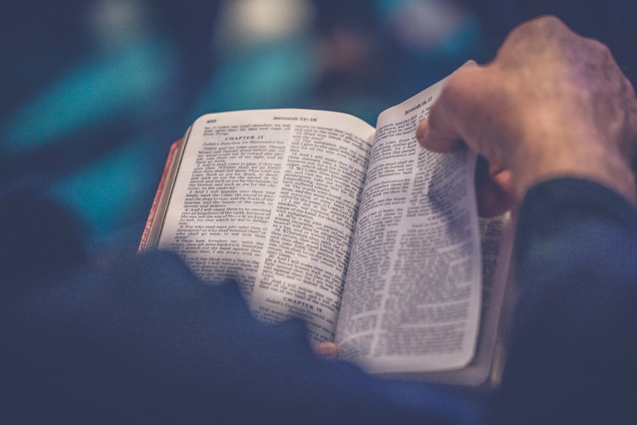An open Bible resting on a wooden table near a window with soft morning light