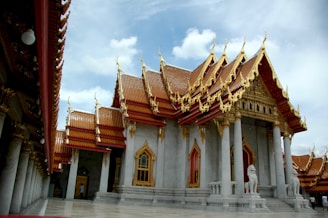 An elegant handcrafted marble temple with intricate floral patterns and gold accents.