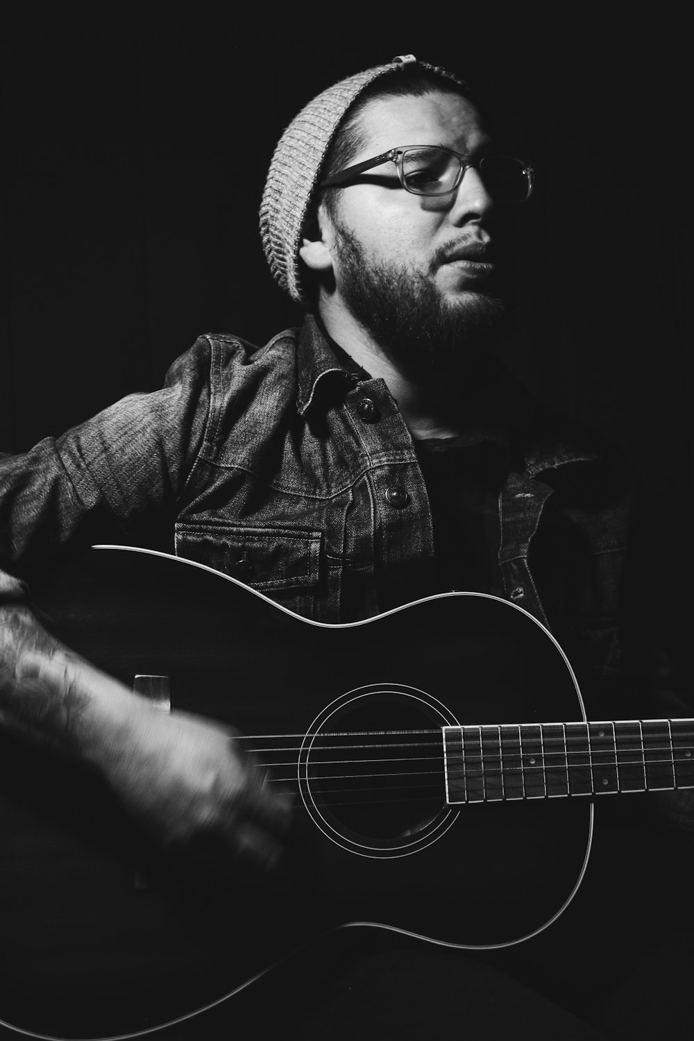 grayscale photo of man playing guitar