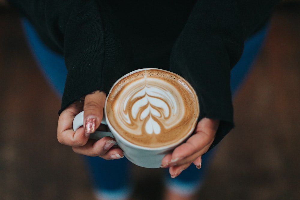 persona che tiene la tazza di caffè