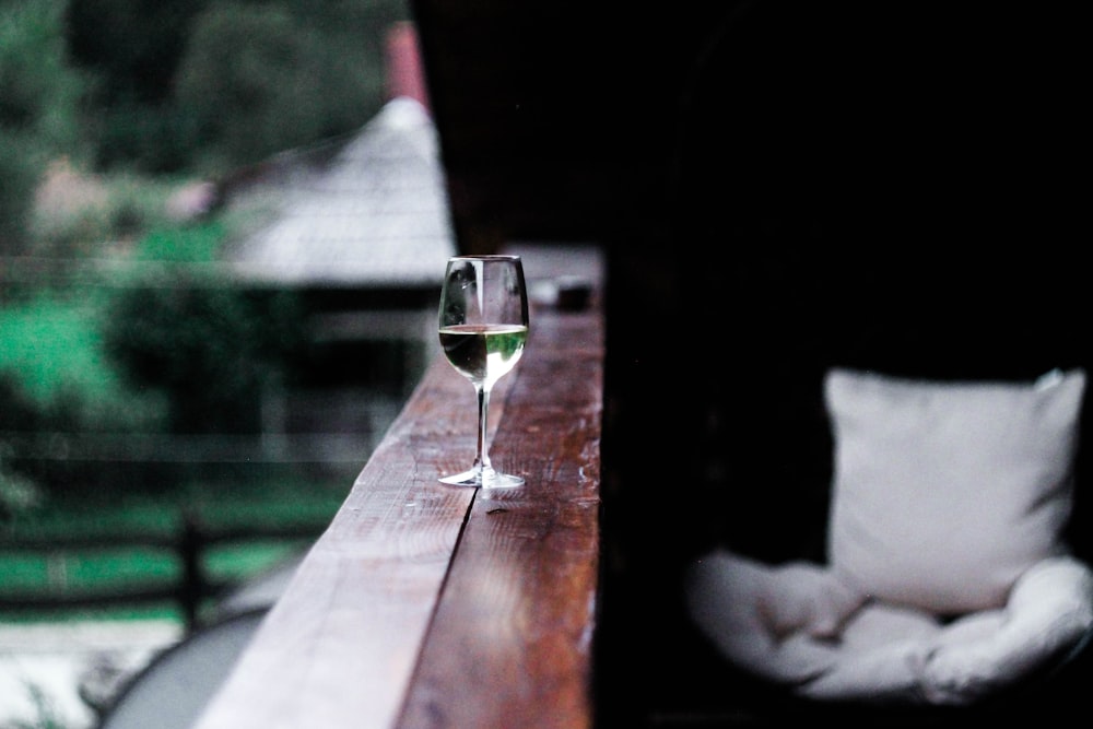 Weinglas auf hölzernem Terrassengeländer
