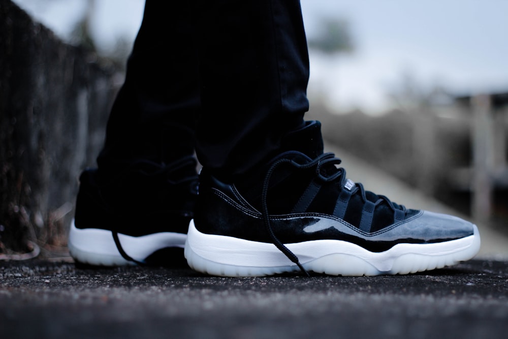 person wearing pair of black Air Jordan 11 shoes