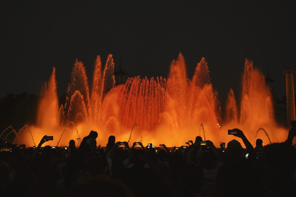 Fotografia di silhouette di persone davanti alla fontana d'acqua