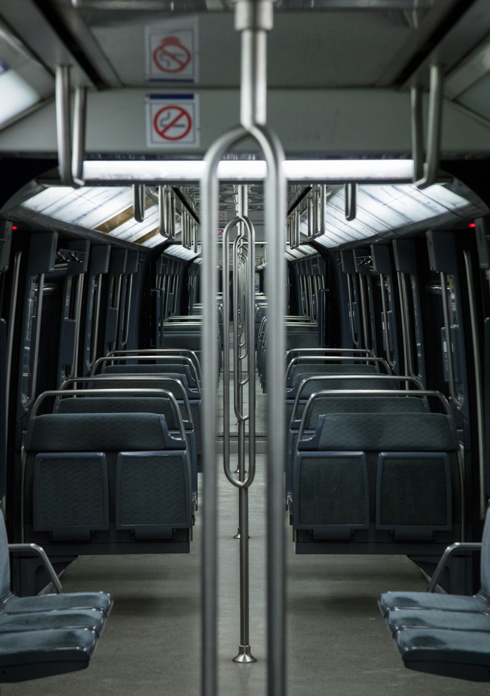 Symmetrical view inside a city subway car with blue seats