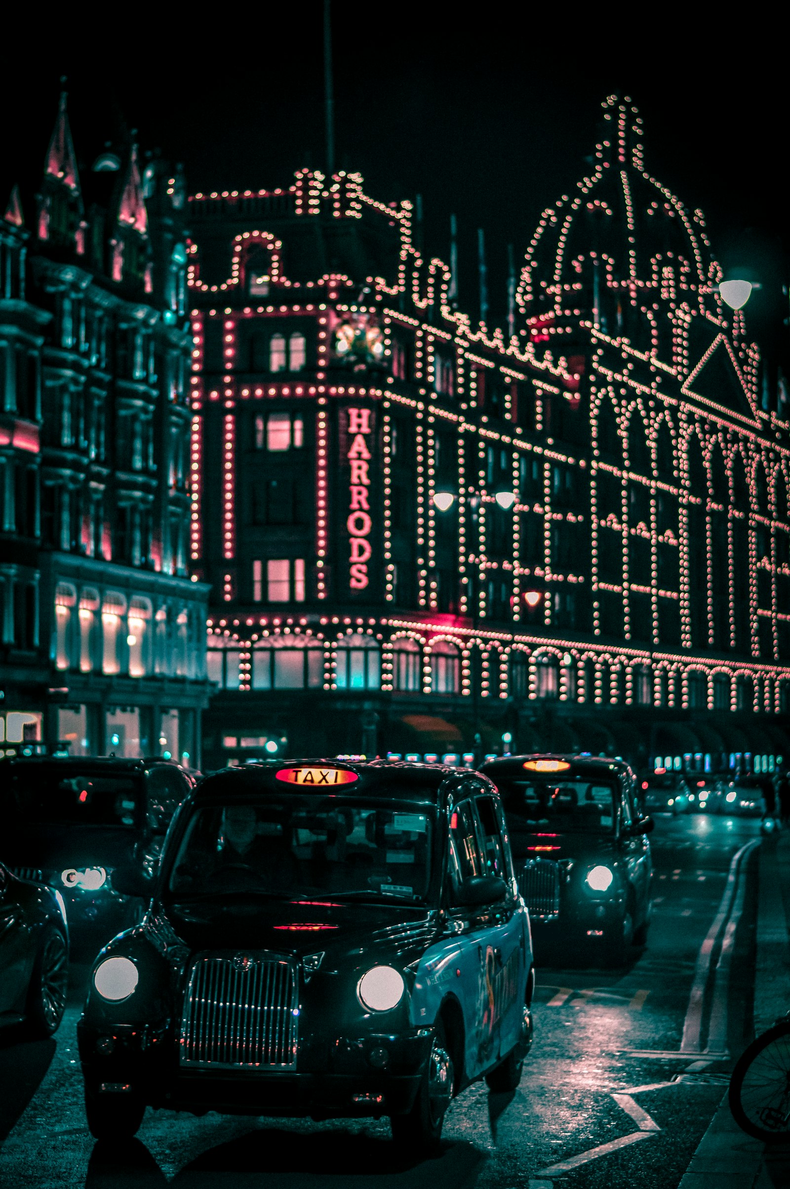 A London taxi passing Harrods at night