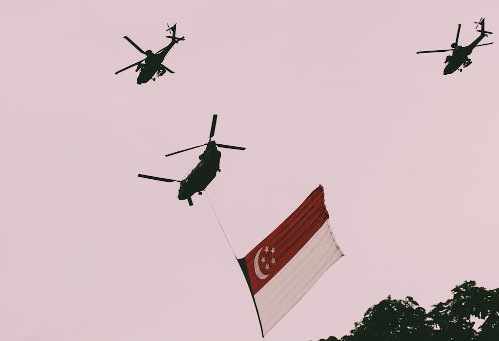 헬리콥터 3대와 깃발이 있는 헬리콥터 1대의 사진