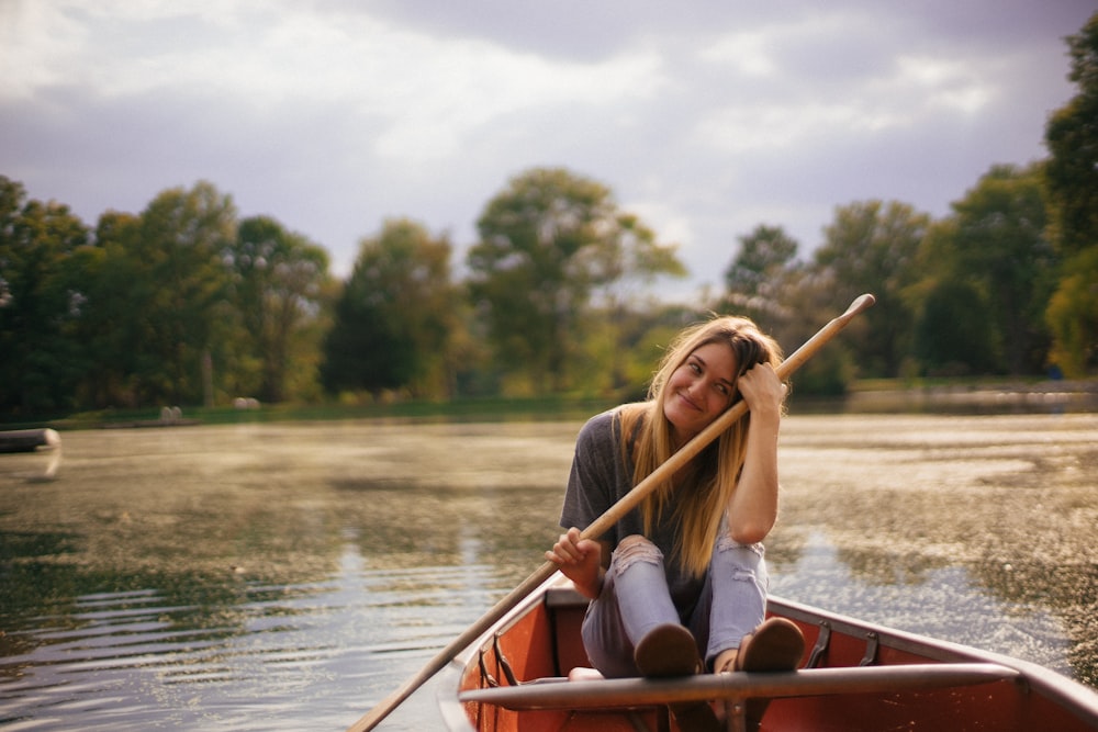 woman riding on boat holding paddle
