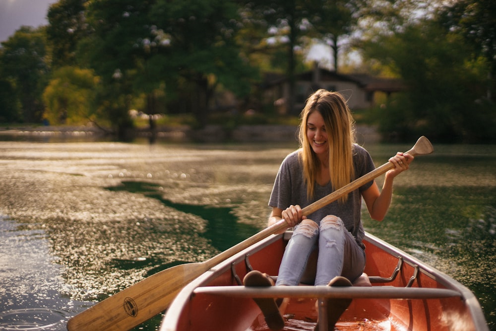 woman sitting in brown paddle boat