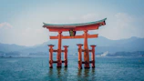 The orange Itsukushima Shrine torii gate standing in the water at Hatsukaichi, Japan