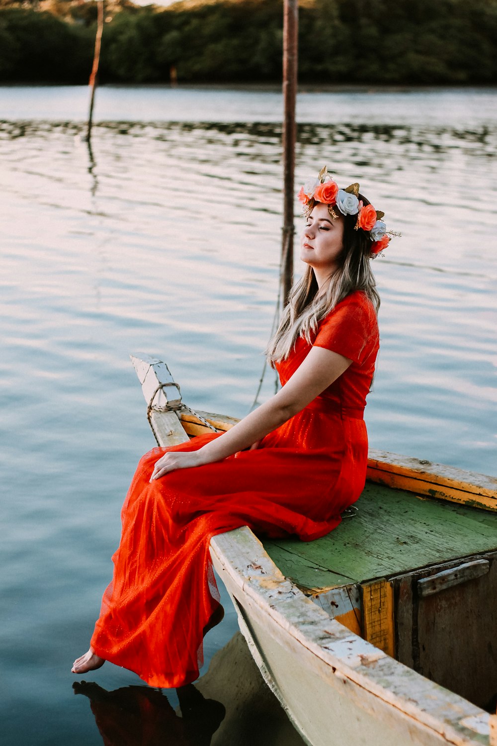 woman sitting on boat in body of water while closing her eyes