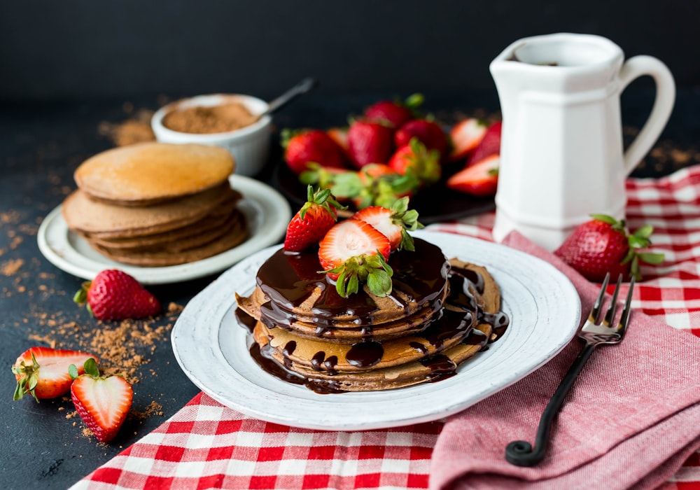 Pancake con sciroppo di cioccolato su piatto di ceramica