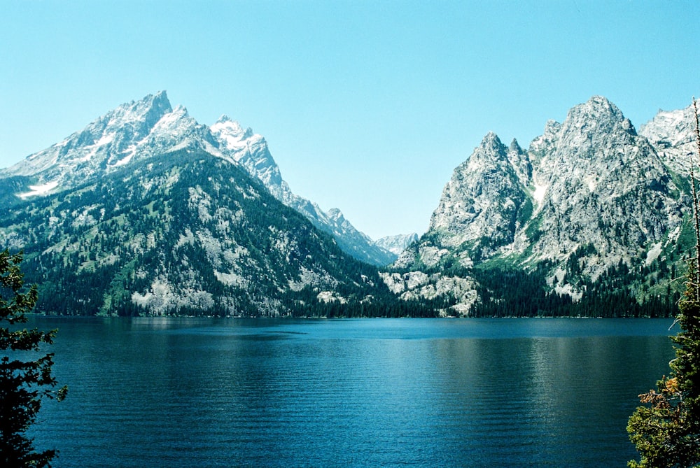 snow covered mountain across lake under clear blue sky