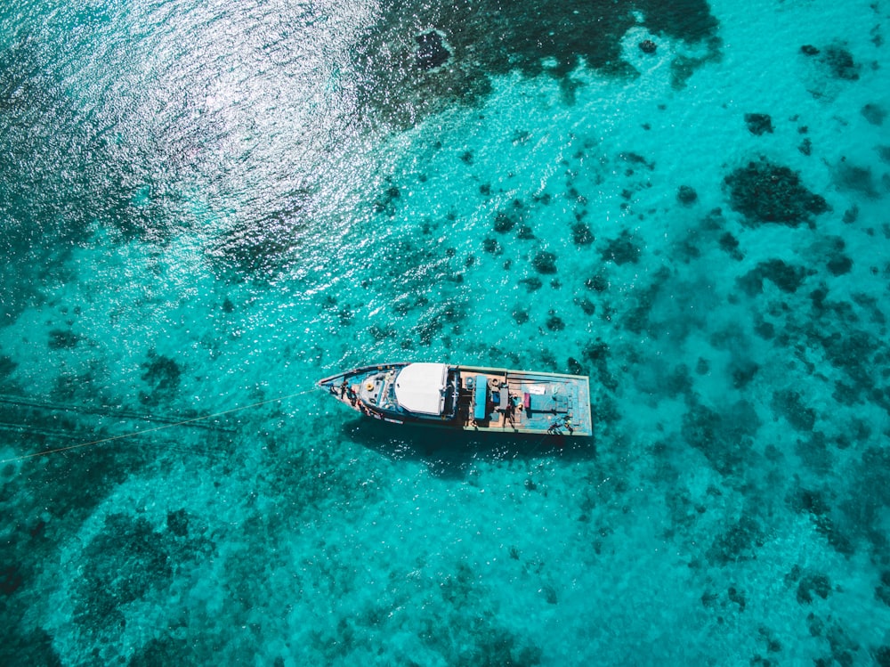 aerial photography on white and blue boat on sea