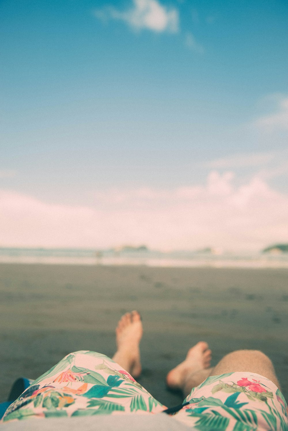 Photographie à mise au point peu profonde d’une personne allongée sur le sable