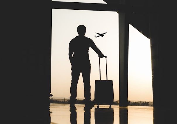 silhouette of man holding luggage inside airport