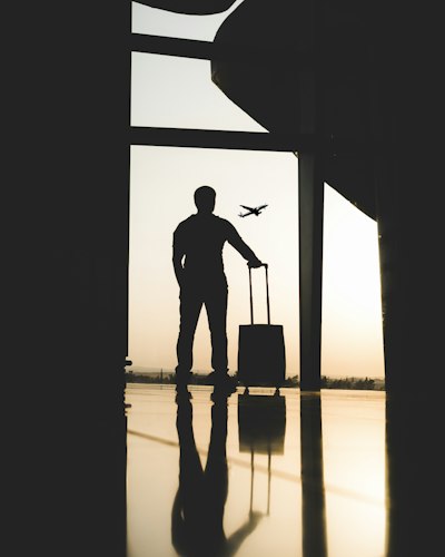 Solo traveler with a backpack looking out over a scenic overlook at sunset