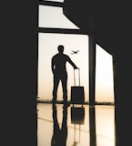 silhouette of man holding luggage inside airport