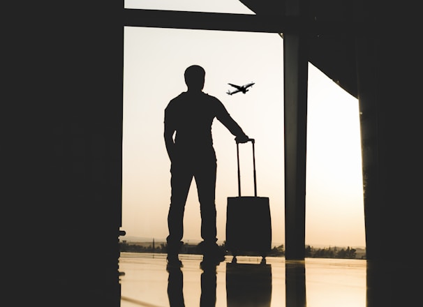 silhouette of man holding luggage inside airport