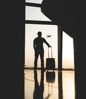 silhouette of man holding luggage inside airport