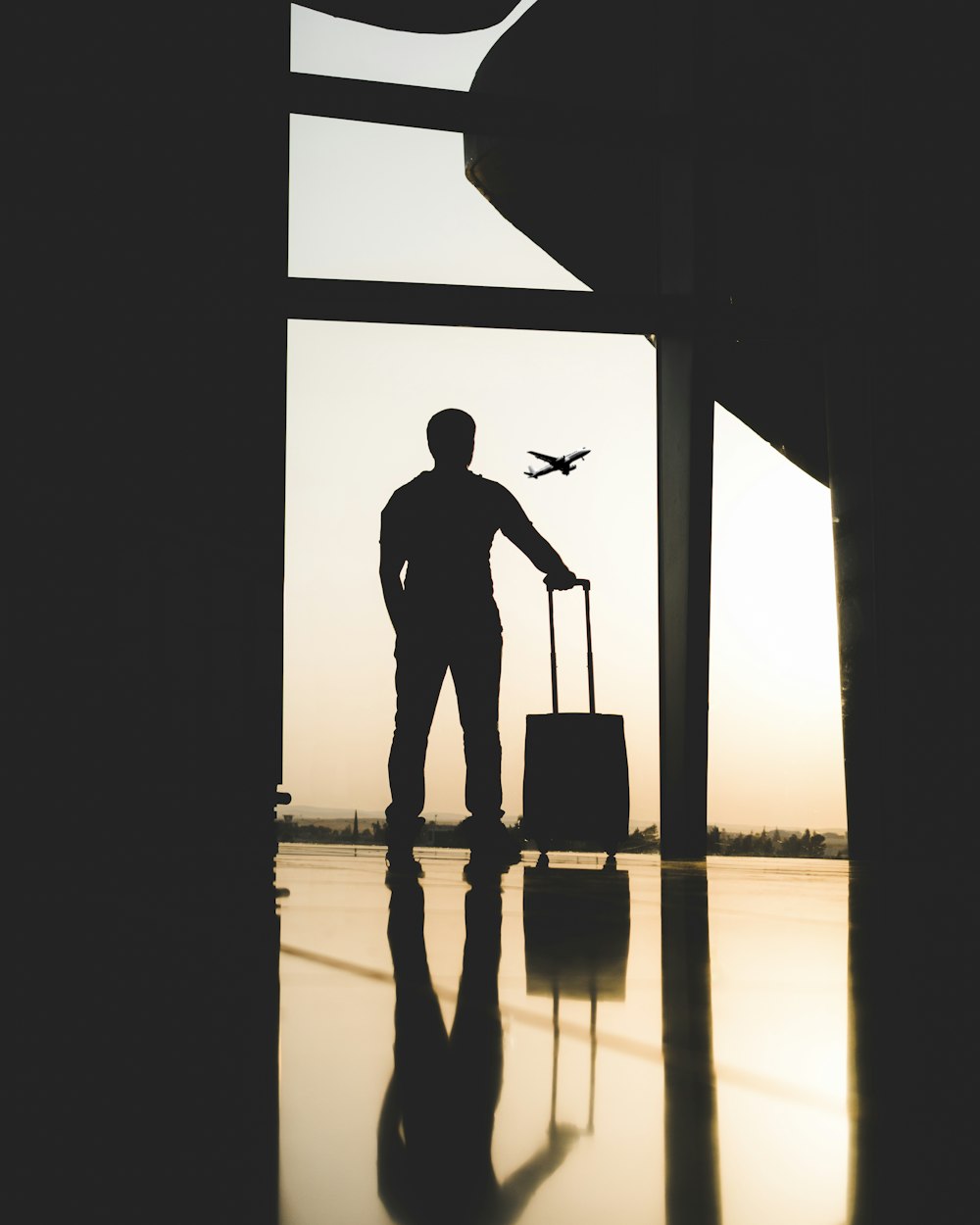 Silueta de hombre sosteniendo equipaje dentro del aeropuerto