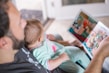 A parent reading an e-book with a child beside them.