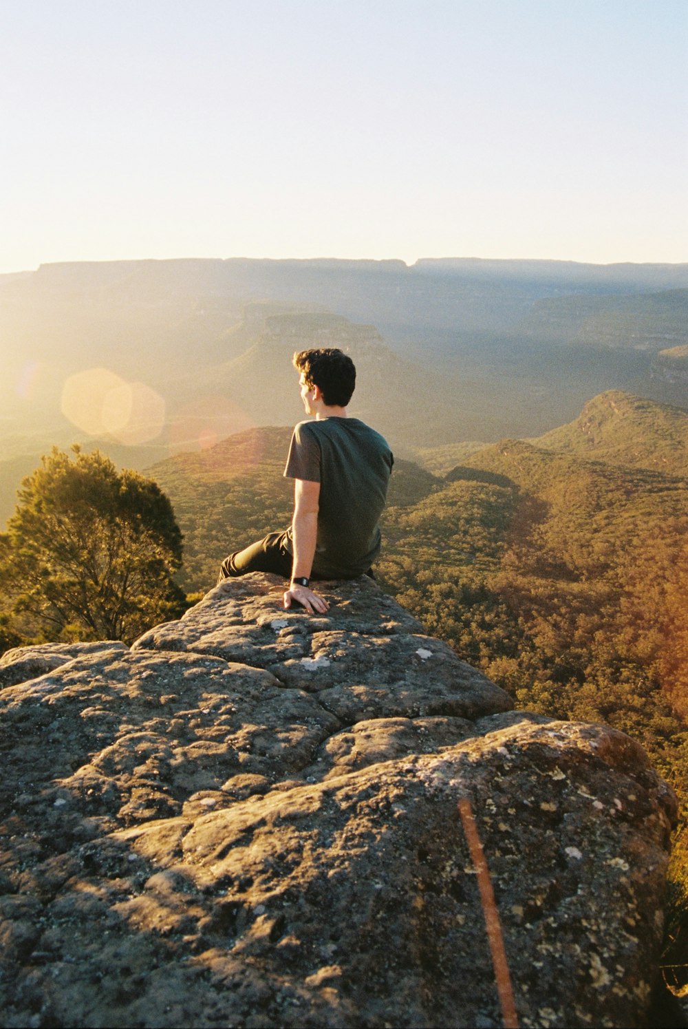 man sitting on rocks looking backwards