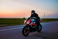 Dynamic shot of a rider cruising on a red and black motorcycle on a highway