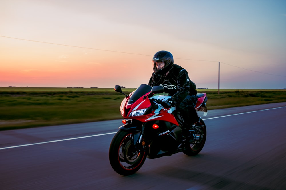 man riding sports motorcycle on road