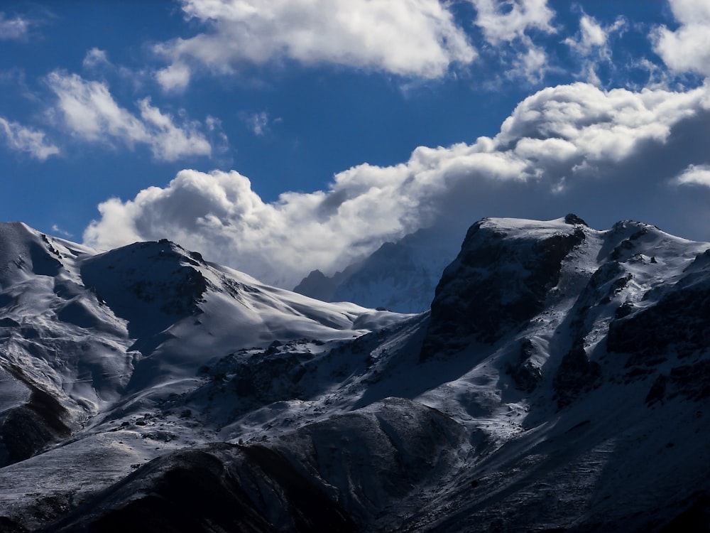 mountain covered with snow under cloudy sky