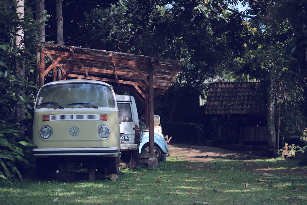 Furgoneta Volkswagen T2 beige aparcada junto al árbol