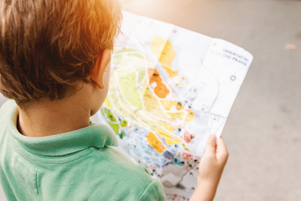 ragazzo in piedi mentre legge la mappa