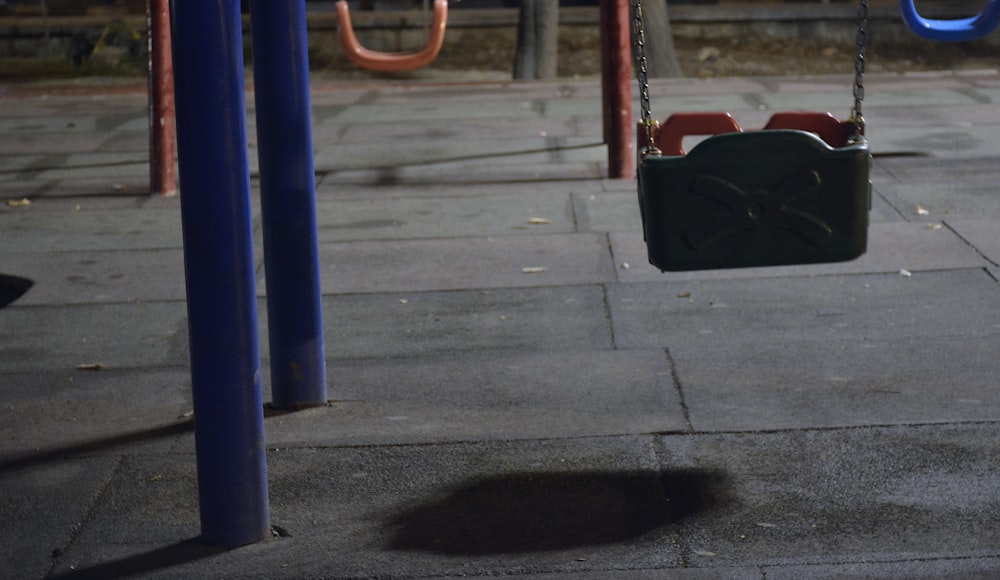 black and red swing on gray concrete ground