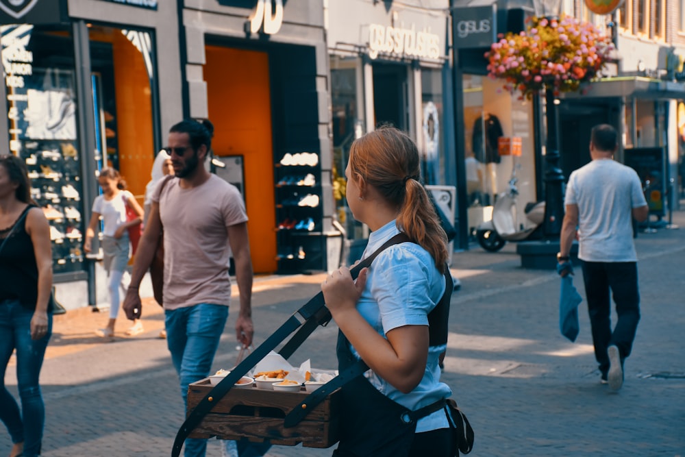 woman carrying brown wooden tray