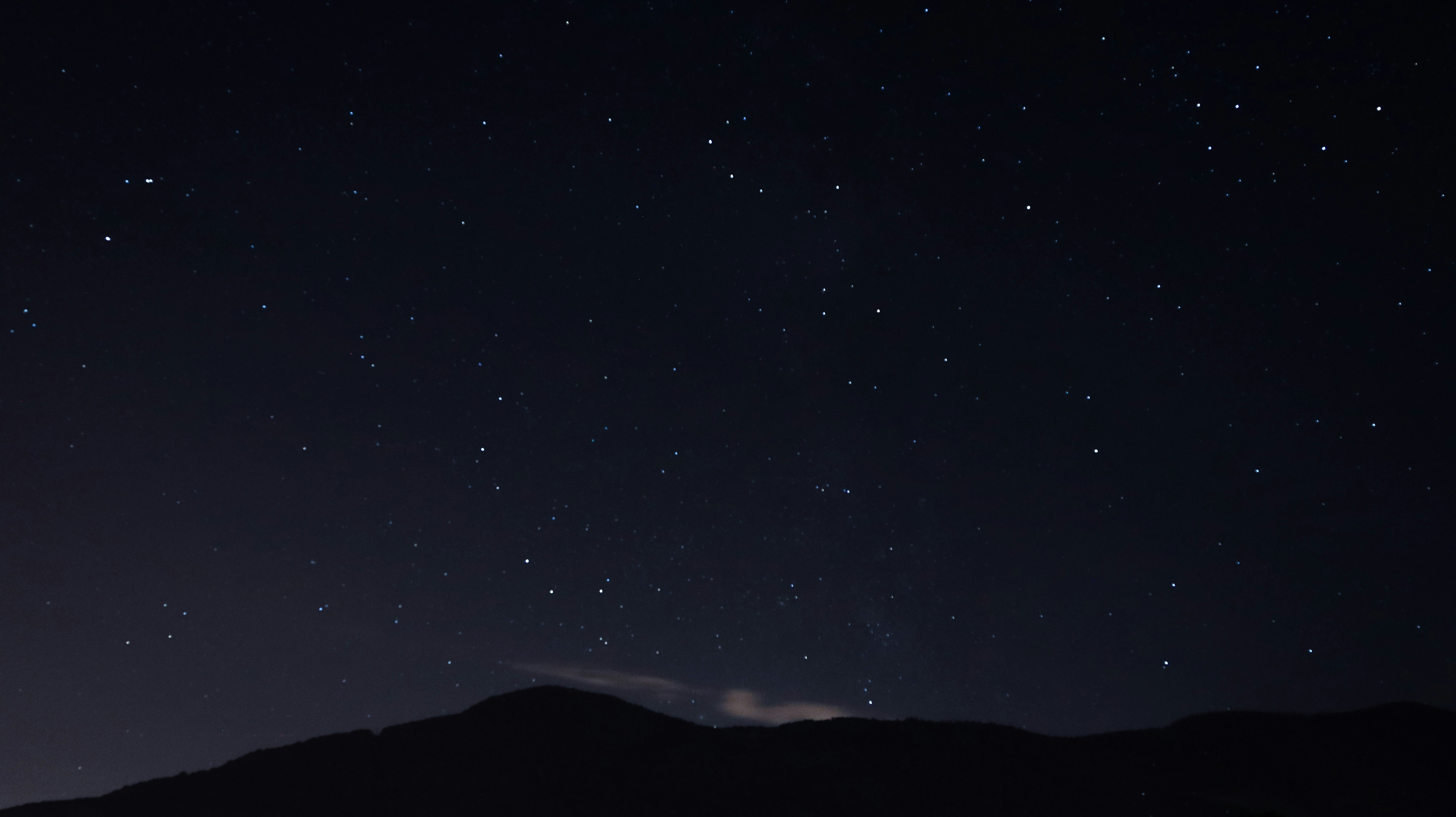 silhouette of mountain under starry night