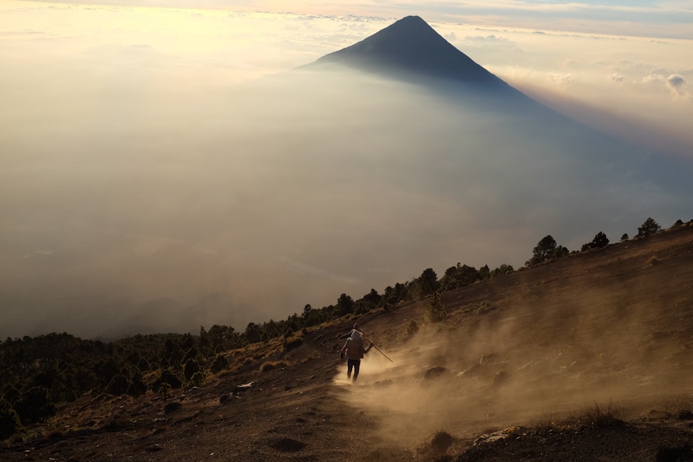 photography of person walking towards mountain