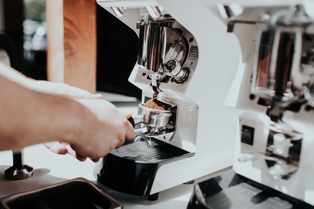 personne utilisant un expresso à l’intérieur de la cuisine