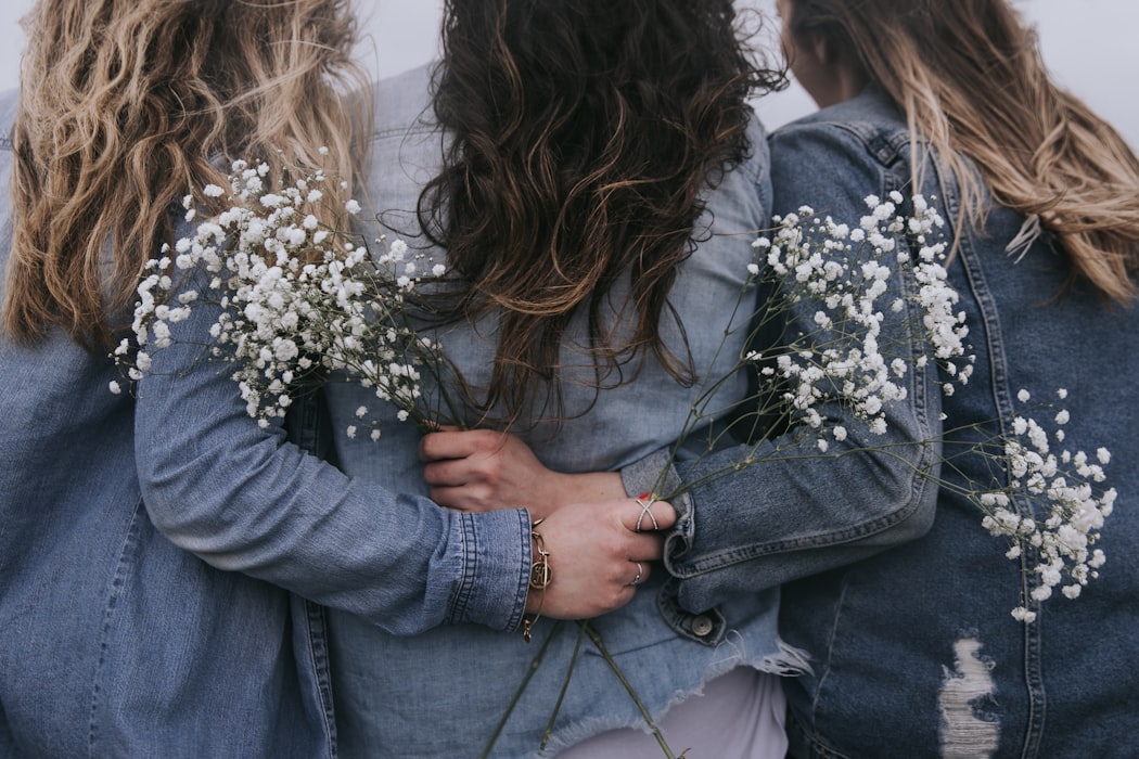 sisters holding flowers wearing denim