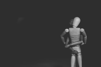 grayscale photo of joint action figure hugging one another