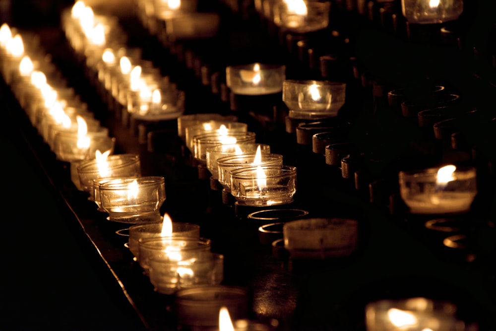 closeup photo of lighted tealight candles on rack
