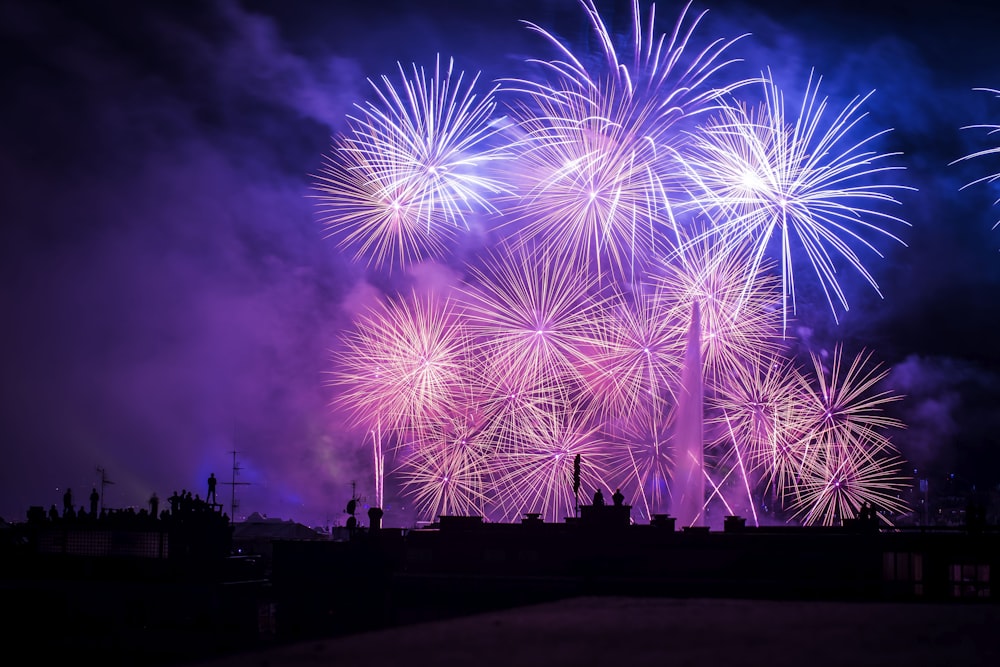 silhouette of buildings with purple and pink fireworks display