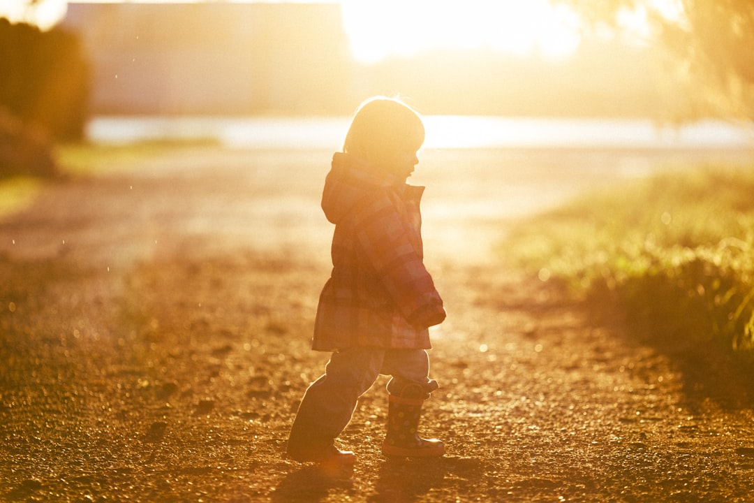 girl walking on ground towards grass