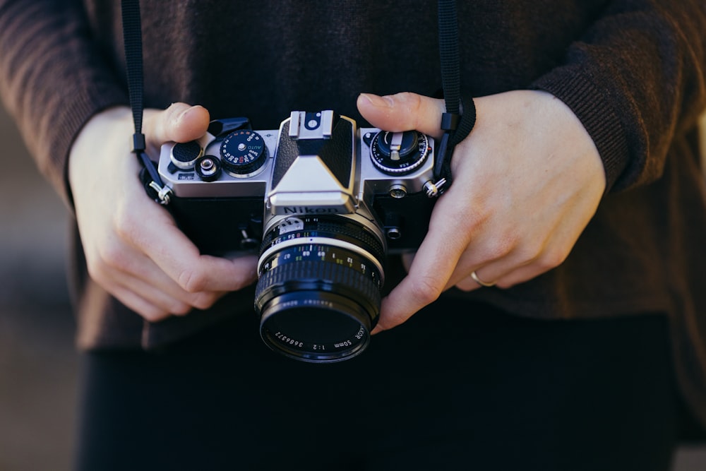 person holding gray and black SSLR camera