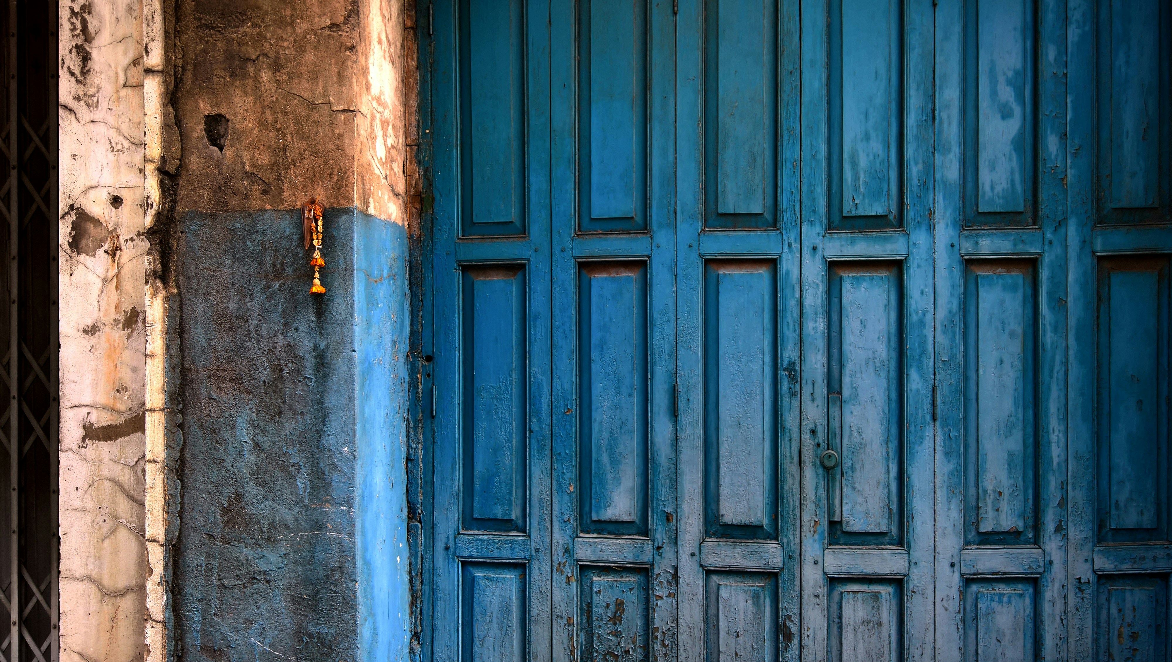 blue wooden door with panels beside blue and brown wooden concrete