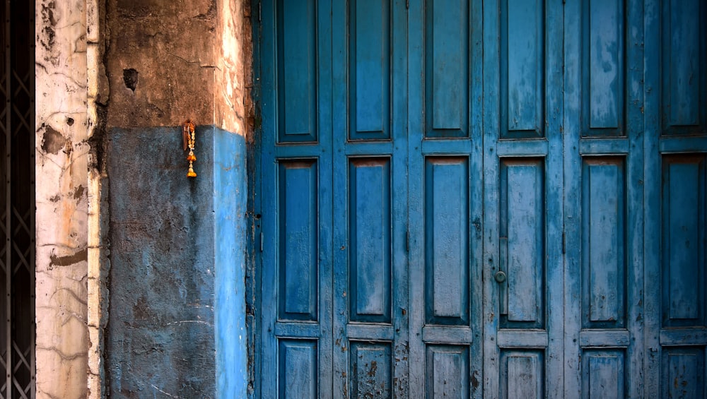 Puerta de madera azul con paneles junto a hormigón de madera azul y marrón
