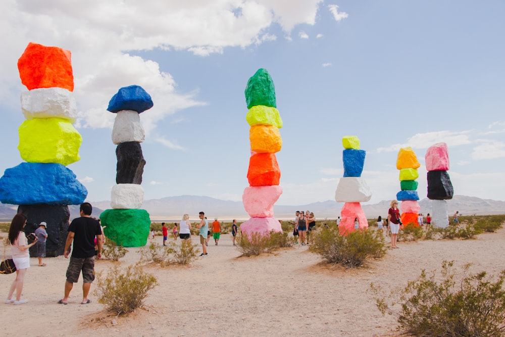 people sightseeing at multicolored stacked rocks landmark during daytime