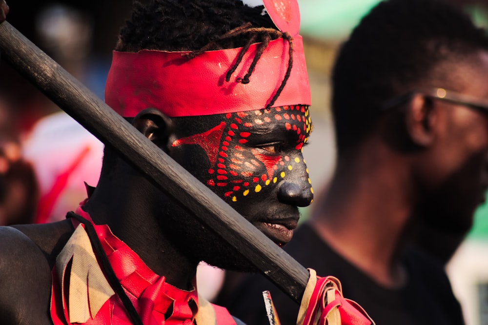 man with red and yellow face paint