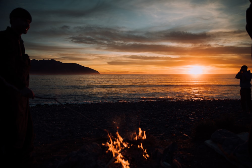 silhouette of person standing near bonfire