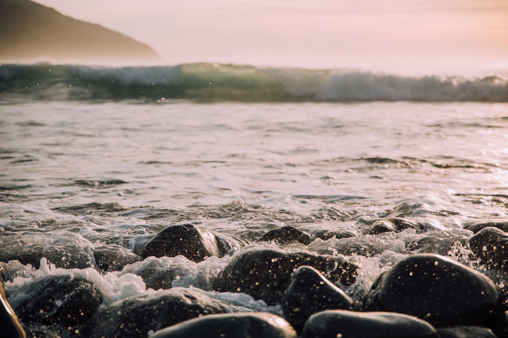 black stones near sea wave