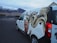 A van parked on a road features a large, detailed graffiti artwork on its side. This artwork includes a stylized portrait of a person with exaggerated, swirling yellow hair. In the background, there are snow-capped mountains and a partly cloudy sky, creating a dramatic natural setting.