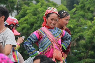 A joyful woman wearing a vibrant ethnic suit set, smiling confidently while walking outdoors.